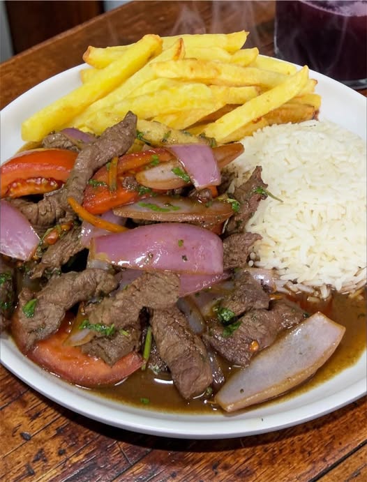 Lomo saltado peruano con patatas fritas, arroz blanco y verduras salteadas